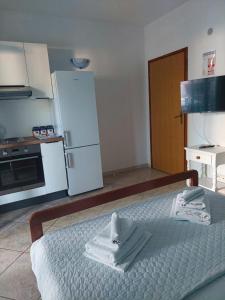 a kitchen with a bed with towels on it at Olive Garden Apartments in Poljica