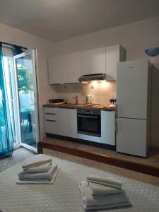 a kitchen with white cabinets and a refrigerator at Olive Garden Apartments in Poljica