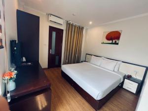 a bedroom with a large white bed in a room at Rising Dragon Hotel in Hanoi
