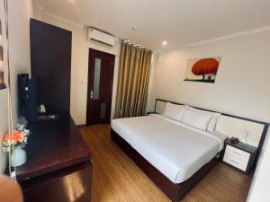 a bedroom with a large white bed in a room at Rising Dragon Hotel in Hanoi