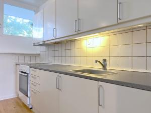 a kitchen with white cabinets and a sink at One Bedroom Apartment In Valby, Langagervej 66, in Copenhagen