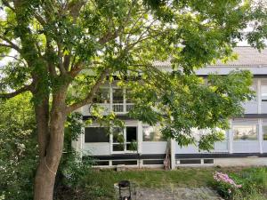 a white house with a tree in front of it at One Bedroom Apartment In Valby, Langagervej 66, in Copenhagen