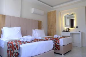 two beds in a hotel room with towels on them at Optimum Luxury Hotel&Spa in Antalya