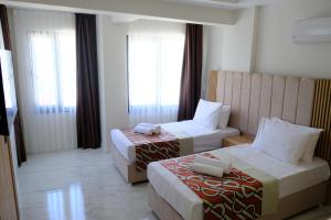 ein Hotelzimmer mit 2 Betten und 2 Fenstern in der Unterkunft Optimum Luxury Hotel&Spa in Antalya