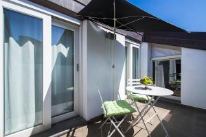 a table and chairs on a balcony with an umbrella at Apartment 23 in Como