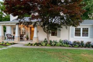a white house with a tree in the front yard at Mill Stream Cottage in Pigeon Forge