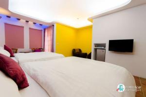 um quarto de hotel com duas camas e uma televisão de ecrã plano em Long Yuan Ju Homestay em Eluan