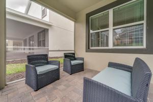a patio with two chairs and a bed and two windows at 9 Bedroom Family Friendly Retreat - Private Pool in Kissimmee