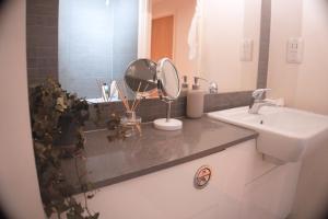 a bathroom with a sink and a mirror on a counter at Luxury London flat 5 min walk to Tube Underground in Hendon