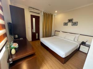 a hotel room with a bed and a television at Rising Dragon Hotel in Hanoi