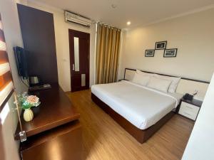 a hotel room with a bed and a television at Rising Dragon Hotel in Hanoi