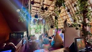 a group of people sitting at a table in a restaurant at A Lounge Hostel in Ella