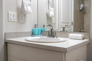 a bathroom counter with a sink and a mirror at Chic 2BR Condo in Vibrant Downtown Calgary in Calgary +33 photos
