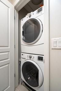 a white washer and dryer in a room at Chic 2BR Condo in Vibrant Downtown Calgary in Calgary