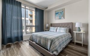 a bedroom with a bed and a window at Chic 2BR Condo in Vibrant Downtown Calgary in Calgary