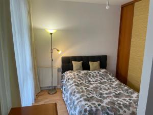 sypialnia z łóżkiem, lampką i stołem w obiekcie Apartament Dominikański Oliwa w Gdańsku