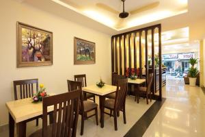 a dining room with tables and chairs in a restaurant at Rising Dragon Hotel in Hanoi