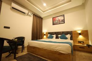 1 dormitorio con cama, escritorio y silla en Radha Bihari Nikunj Inn, en Vrindāvan