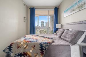 a bedroom with a bed and a window with a view at City Centre Retreat - 1BR Condo with Desk in Calgary