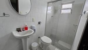 a bathroom with a toilet and a sink and a shower at Presto Hotel in Blumenau