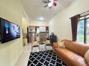 sala de estar con sofá y TV de pantalla plana en Arunni garden, en Bogor