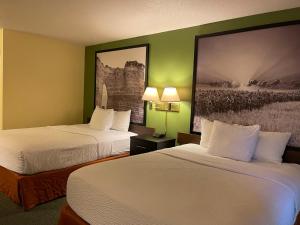 ein Hotelzimmer mit 2 Betten und einem Gemälde an der Wand in der Unterkunft Super 8 by Wyndham Colby in Colby