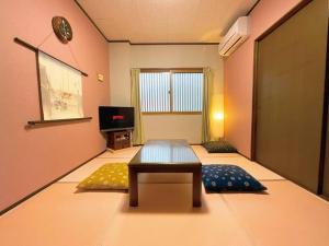 una stanza con un tavolo e due tappeti di Sushi House a Shingū