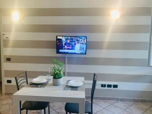 a dining room with a table and a tv on a striped wall at Il Cortiletto in Somma Lombardo