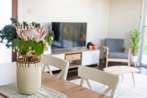 wazon kwiatów na stole w salonie w obiekcie Peaceful Hills Escape: Charming 2-Story Retreat w mieście Upper Sturt
