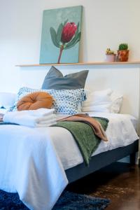 Cama con sábanas y almohadas azules y blancas en Peaceful Hills Escape: Charming 2-Story Retreat, en Upper Sturt