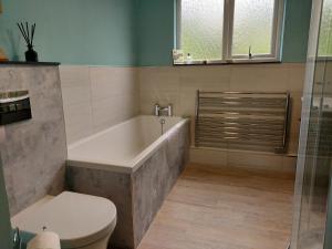 La salle de bains est pourvue d'une baignoire et de toilettes. dans l'établissement Heightley House, à Tintagel
