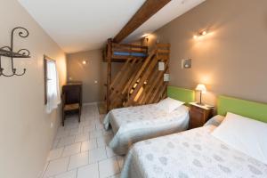 a hotel room with two beds and a tv at Domaine Saint Julien in Buis-les-Baronnies