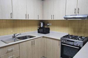 a kitchen with a sink and a stove at Dream studio panoramic beach and sea view in Ras al Khaimah