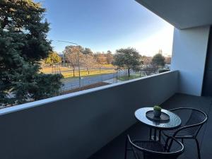 a table and two chairs on a balcony with a window at Modern Griffith Apartment in Kingston 