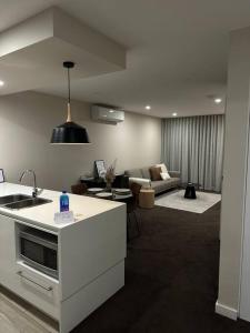 a room with a kitchen and a living room with a couch at Modern Griffith Apartment in Kingston 