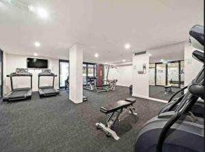 a gym with several treadmills and machines in it at Modern Griffith Apartment in Kingston 