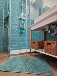 y baño con azulejos azules, lavamanos y alfombra. en Casa Porto Ercole, en Porto Ercole