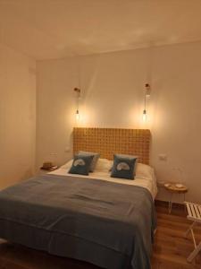1 dormitorio con 1 cama grande y 2 almohadas azules en Casa Porto Ercole, en Porto Ercole