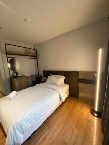 a bedroom with a large white bed and wooden floors at Merchant Express Bintulu in Bintulu