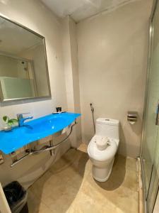 a bathroom with a toilet and a sink and a mirror at Merchant Express Bintulu in Bintulu