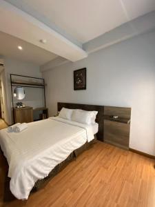a bedroom with a large bed with white sheets at Merchant Express Bintulu in Bintulu