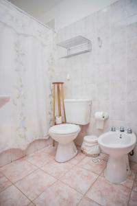 a white bathroom with a toilet and a sink at Hostería Bella Ushuaia in Ushuaia