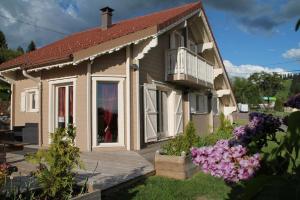 uma pequena casa com um alpendre e uma varanda em Chalet Le Roncing em Gérardmer