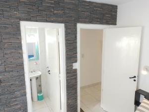 a bathroom with two doors and a brick wall at Departamentos Necochea Playa in Necochea