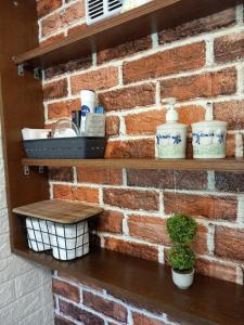 uma parede de tijolos com prateleiras com pratos e uma planta em Green cottage em Blidinje