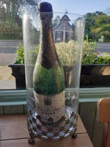 una botella de vino sentada en una mesa en Ma Campagne - Le Jardin, en Auberville