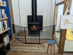 a stove in a room with a book shelf at 猫と図書館のある宿 草地家 Kusachike in Minamiawaji