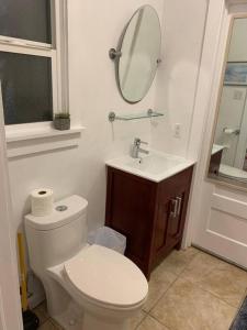 y baño con aseo, lavabo y espejo. en EL Cerrito Home - Private Rooms with Shared Bathroom near Berkeley SFO en El Cerrito