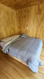 Una cama en una habitación con una pared con escritura. en El Bosque en San Carlos de Bariloche