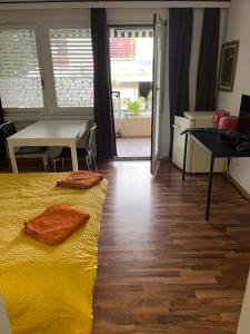 1 dormitorio con cama amarilla, mesa y escritorio en Guesthouse Juerg, en Sempach